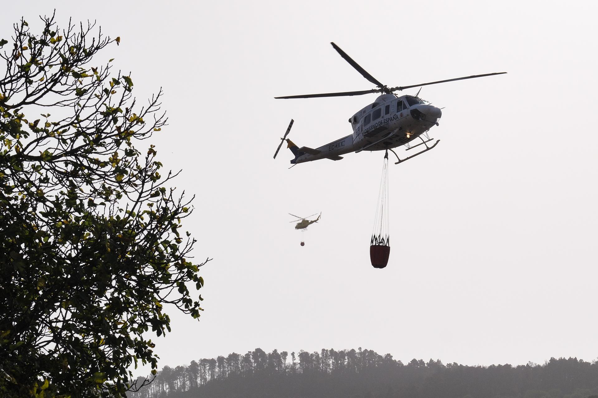 Foto de archivo de dos helicópteros trasladando agua a la zona de la reactivación del incendio forestal de Tenerife, en el municipio de El Sauzal. EFE/Alberto Valdés