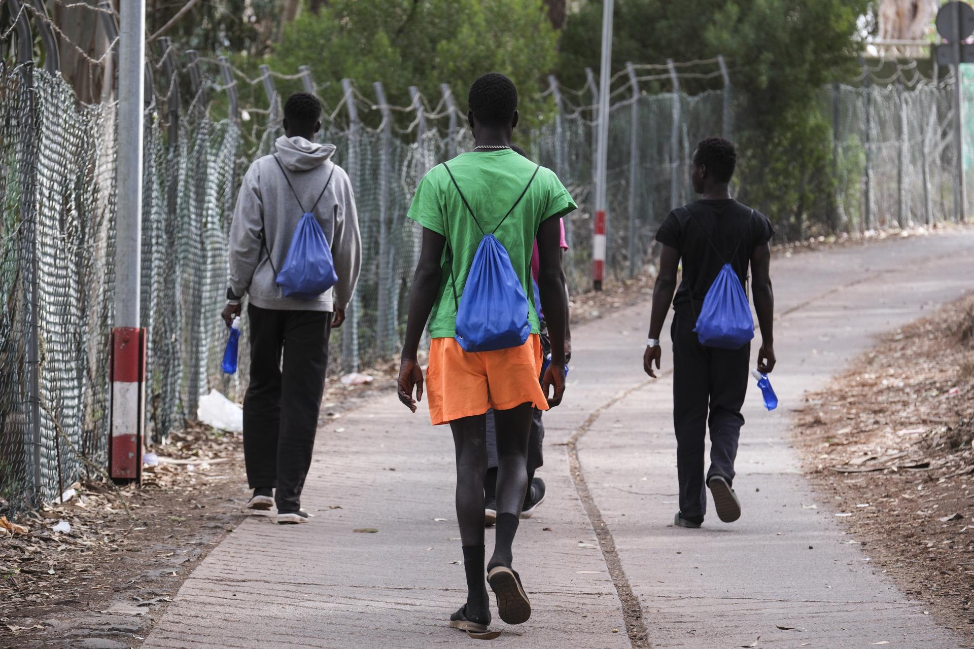 Cuatro jóvenes africanos caminan por el exterior del centro de acogida de Las Raíces, en La Laguna (Tenerife), donde han sido alojados buena parte de las personas que han llegado en los últimos días en cayuco a El Hierro.EFE/Alberto Valdés