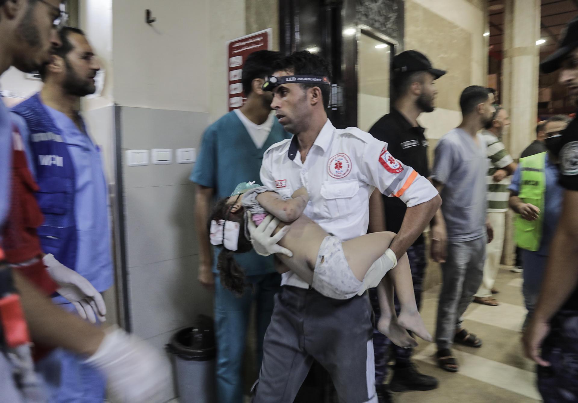 A paramedic holds a wounded child at a hospital in Khan Younis, in the southern Gaza Strip, 17 October 2023. EFE-EPA/HAITHAM IMAD

