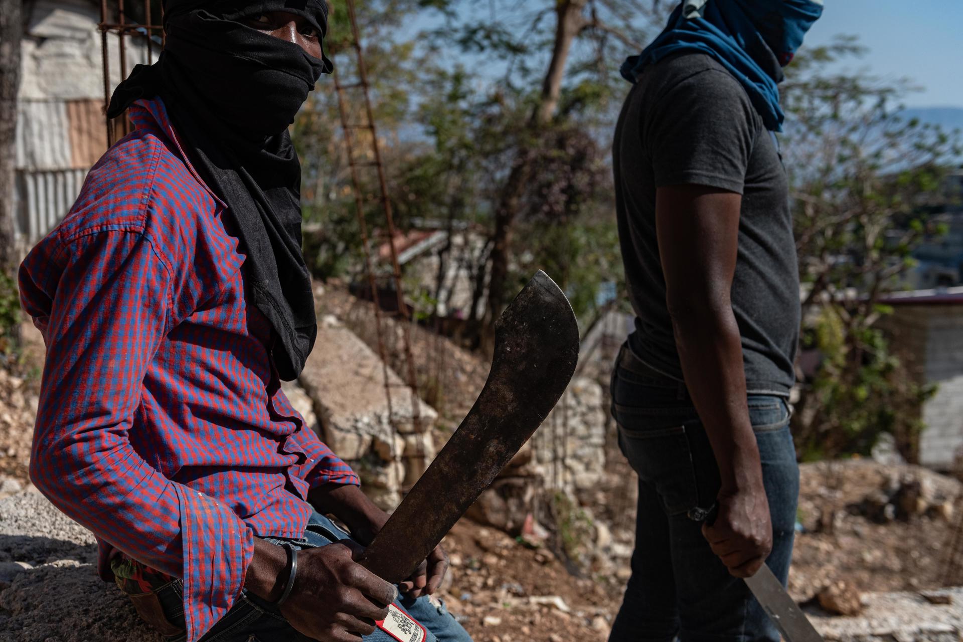Members of a self-defense group pose with machetes, on March 31, 2023, on a street in Diégue, a neighborhood in the Petion-ville commune, in Port-au-Prince (Haiti). With illegal weapons, machetes, Molotov cocktails and even bottles and pieces of wood, young Haitians go out in brigades, regularly at night, to try to defend the entrances to their neighborhoods from the bloody attacks of the gangs. EFE/ Johnson Sabin
