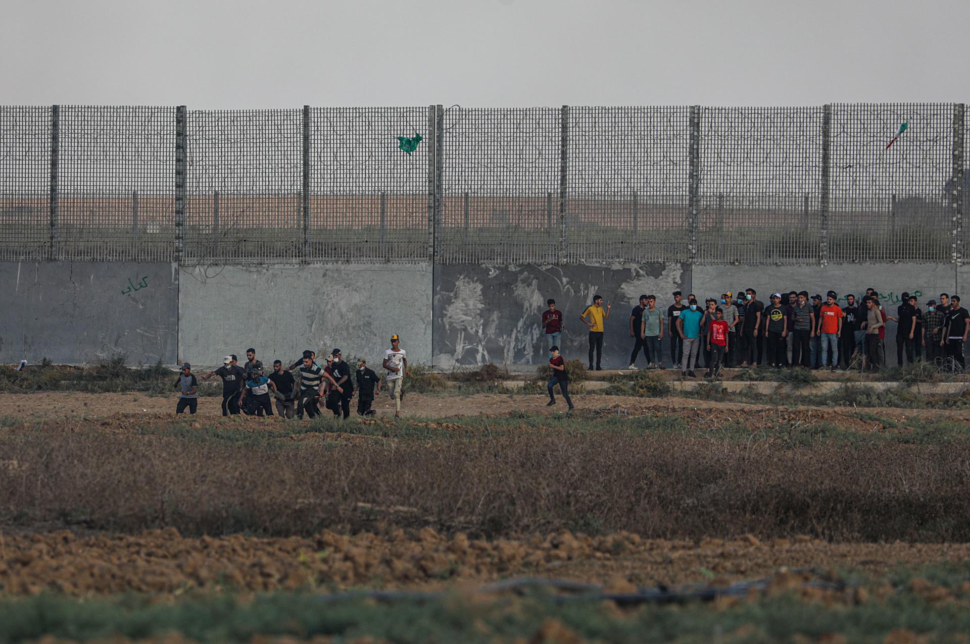 Palestinians carry a wounded protester near the border wall during clashes on the eastern border of the Gaza Strip, 22 September 2023. EFE-EPA/FILE/MOHAMMED SABER
