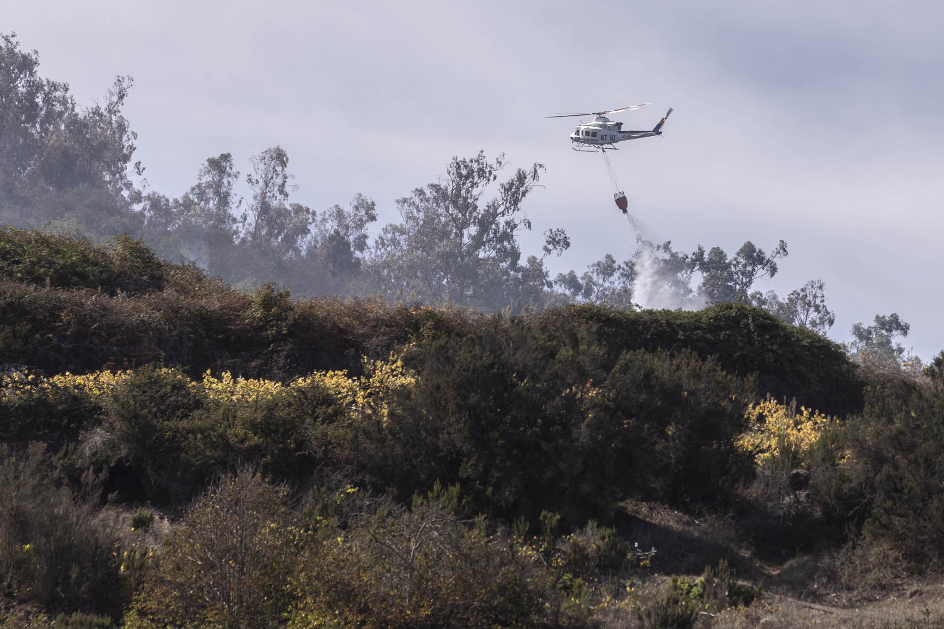 Imagen de la pasada semana de un helicóptero refrescando la zona del incendio forestal en el municipio tinerfeño de Santa Úrsula. EFE/Miguel Barreto