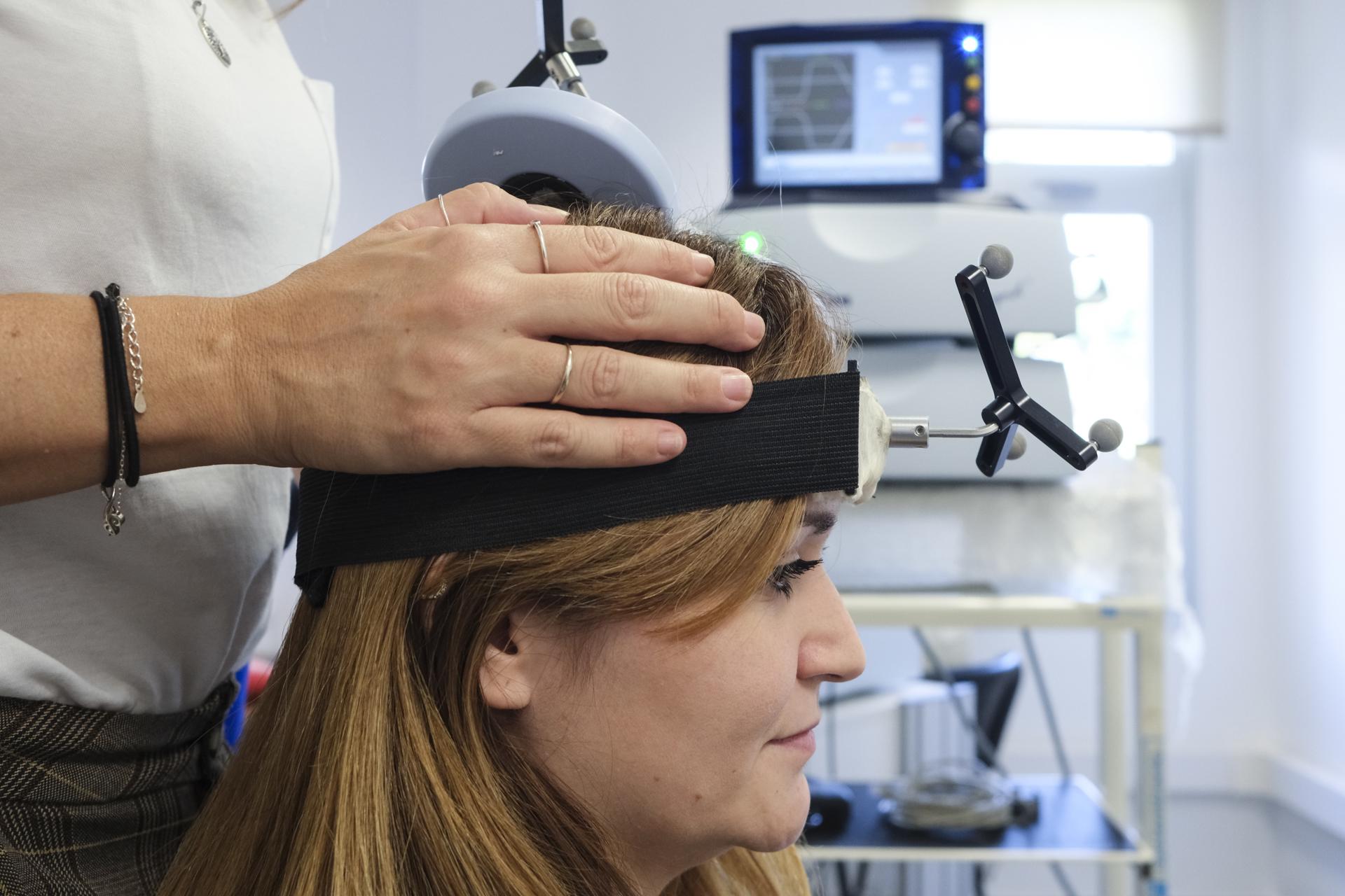 Una investigadora del IUNE realiza con una voluntaria una prueba para el estudio de la actividad cerebral en las instalaciones del centro en La Laguna. EFE/Alberto Valdés