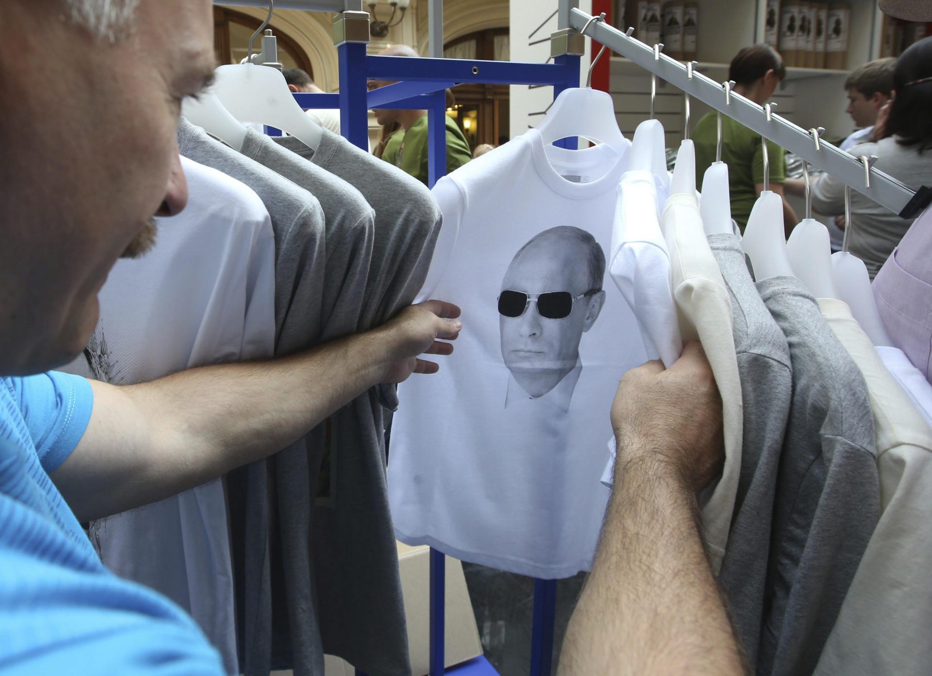 Un hombre observa una camiseta con la fotografía del presidente ruso, Vladimir Putin, en un mercadillo de Moscú (Rusia), en una imagen de archivo. EFE/Sergei Chirikov
