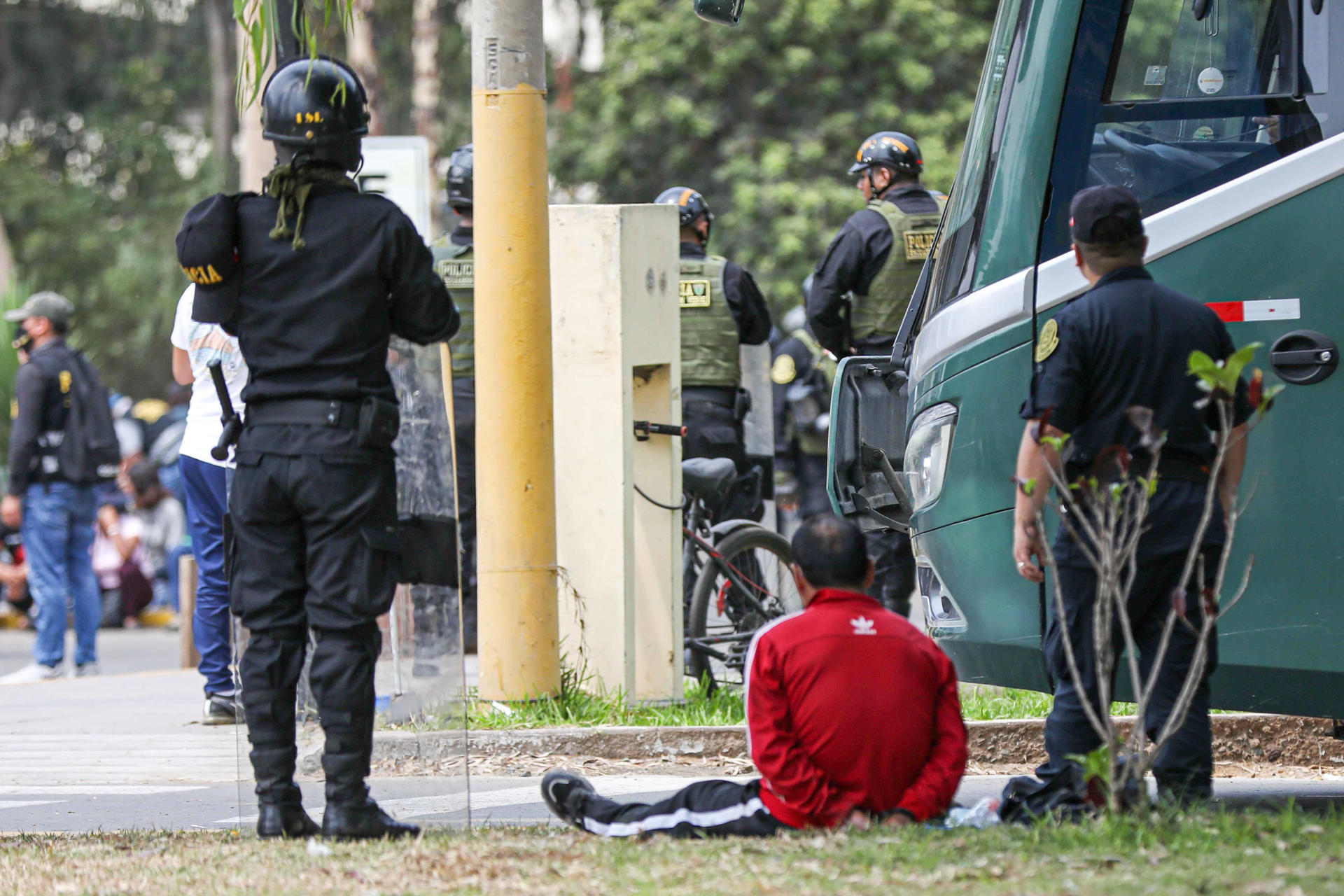 Integrantes de la Policía Nacional de Perú (PNP) vigilan a una persona detenida en Lima (Perú), en una fotografía de archivo. EFE/Connie Calderón