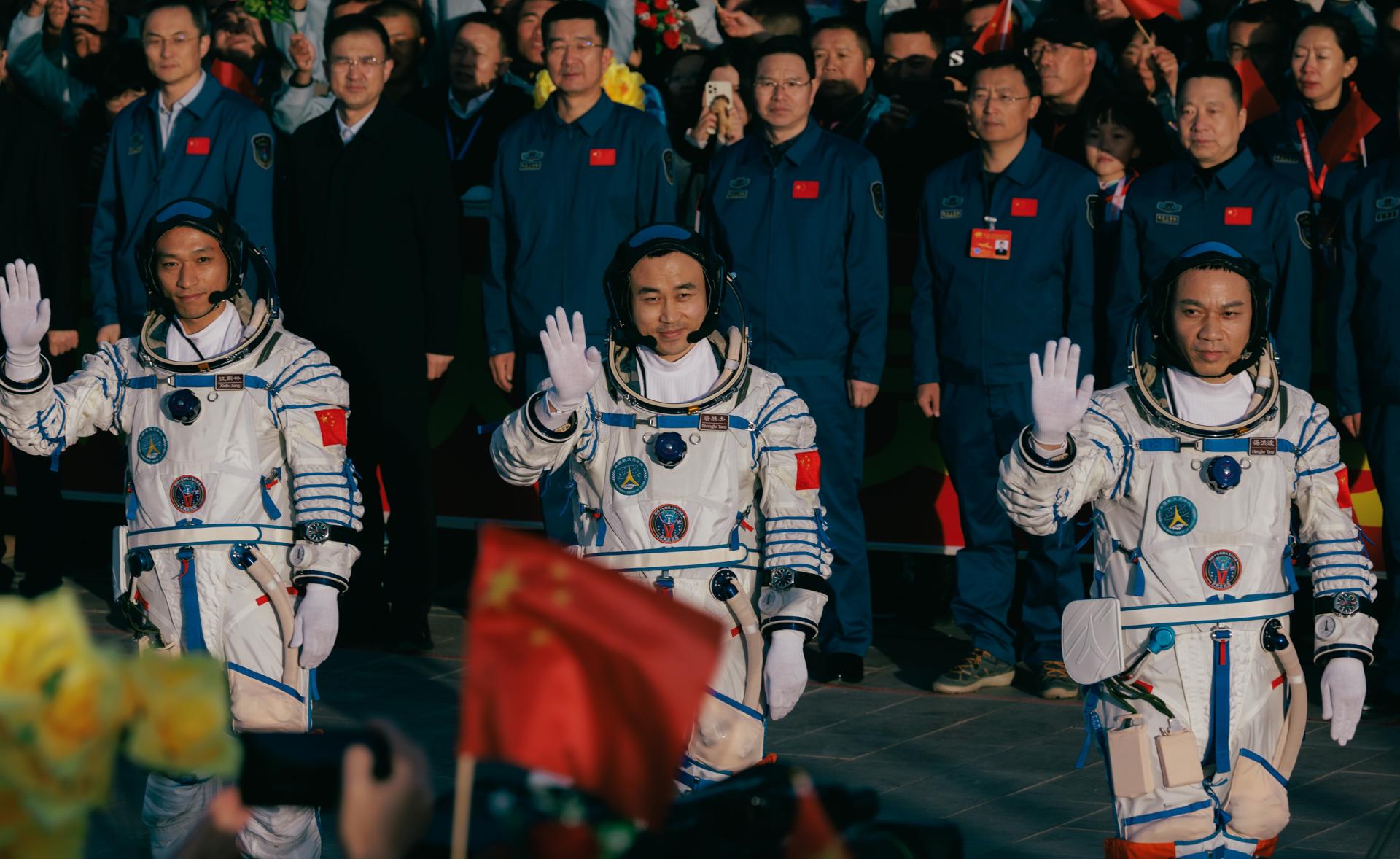 A Shenzhou-17 manned spaceflight mission astronauts commander Tang Hongbo (R), Tang Shengjie (C), and Jiang Xinlin (L) wave during the see-off ceremony before the launch in Jiuquan, Gansu province, China, 26 October 2023. EFE-EPA/ALEX PLAVEVSKI
