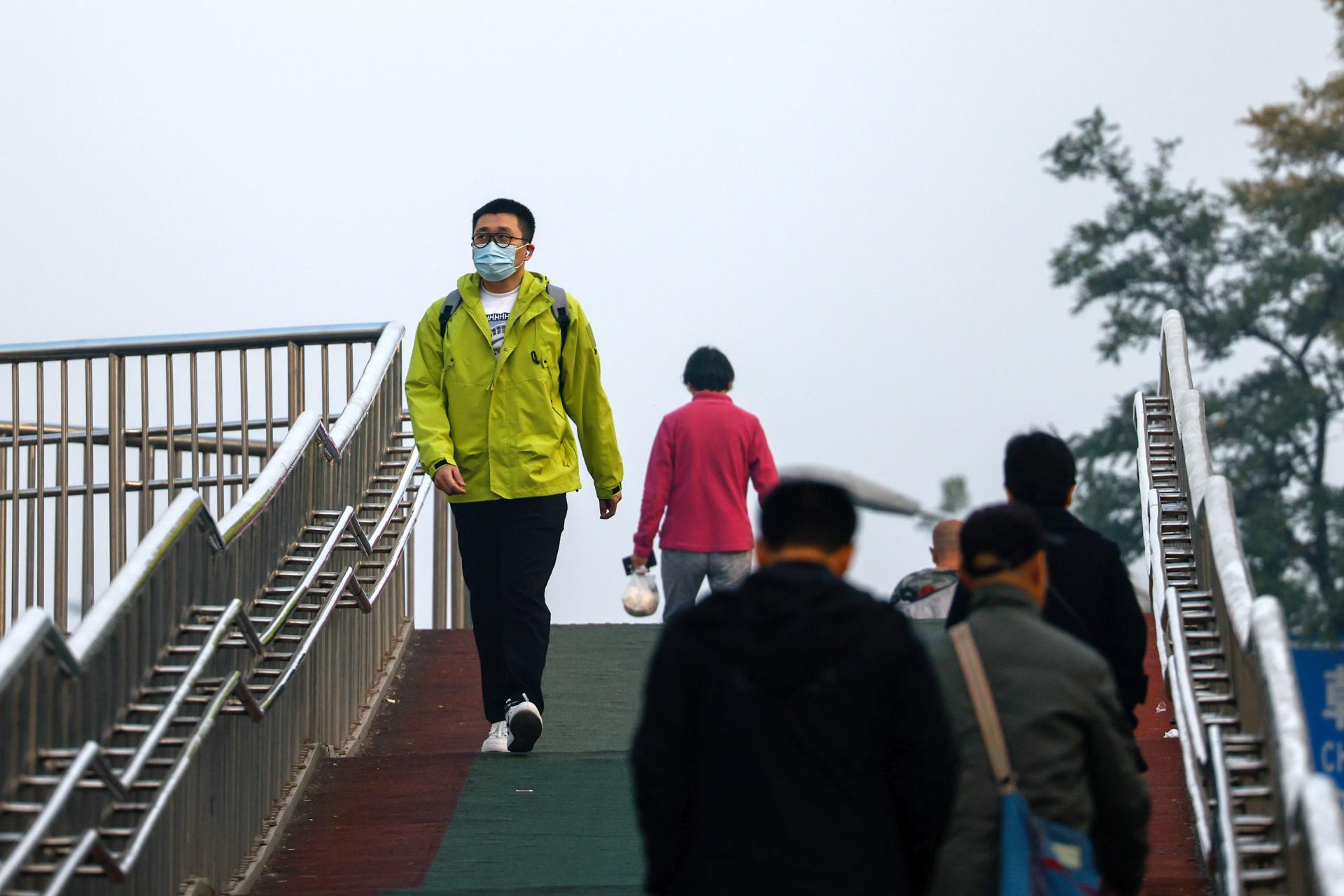 A man wears a face mask as he walks on an overpass in Beijing, China, 30 October 2023. EFE/EPA/MARK R. CRISTINO
