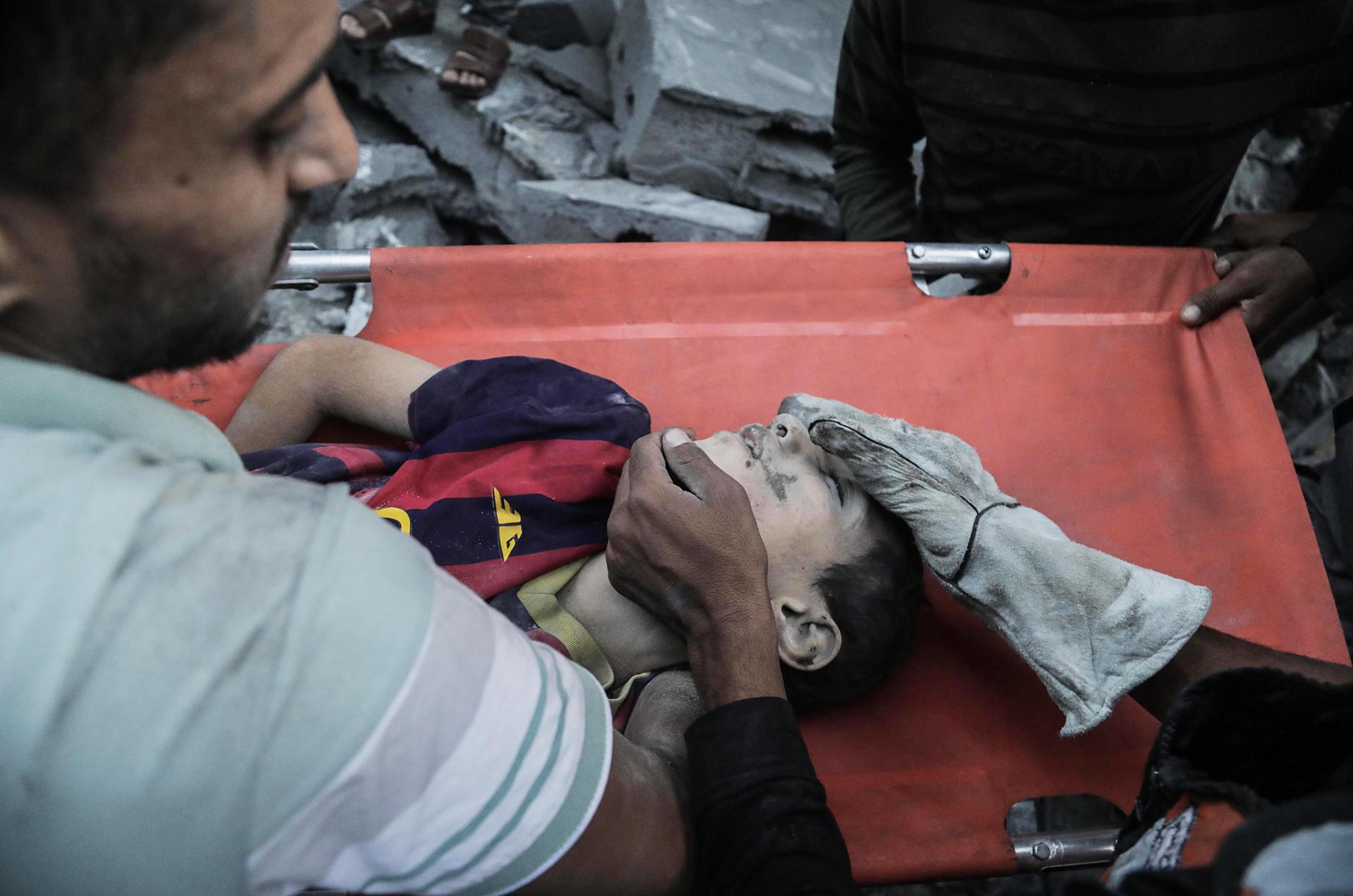 A child is recovered from the rubble of a residential building leveled in an Israeli airstrike, in Khan Younis refugee camp in the southern Gaza Strip, 19 October 2023. EFE-EPA/HAITHAM IMAD
