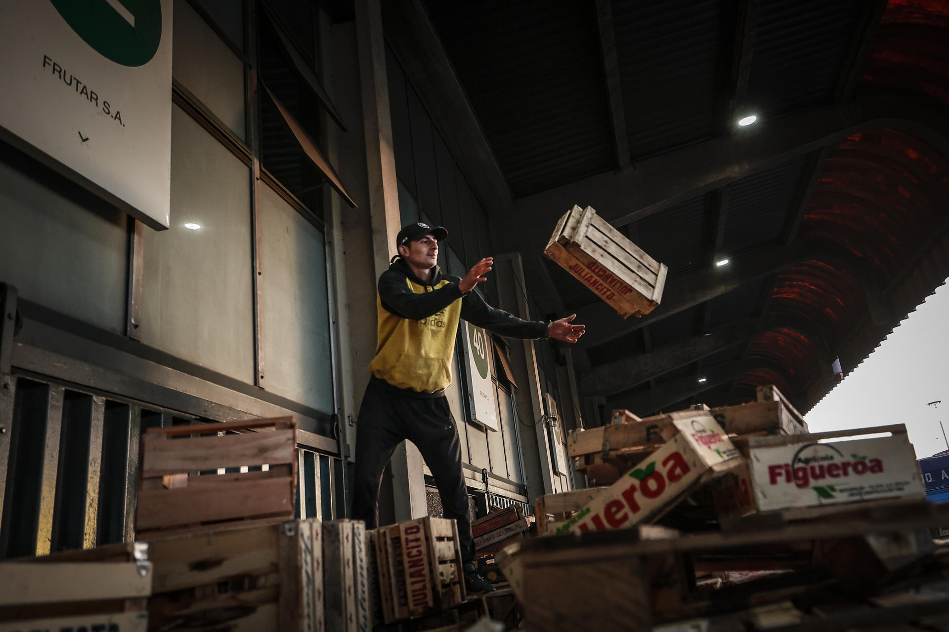 A man throws a box at the Central Fruit and Vegetable market in Buenos Aires, Argentina, 13 April 2023. EFE/Juan Ignacio Roncoroni