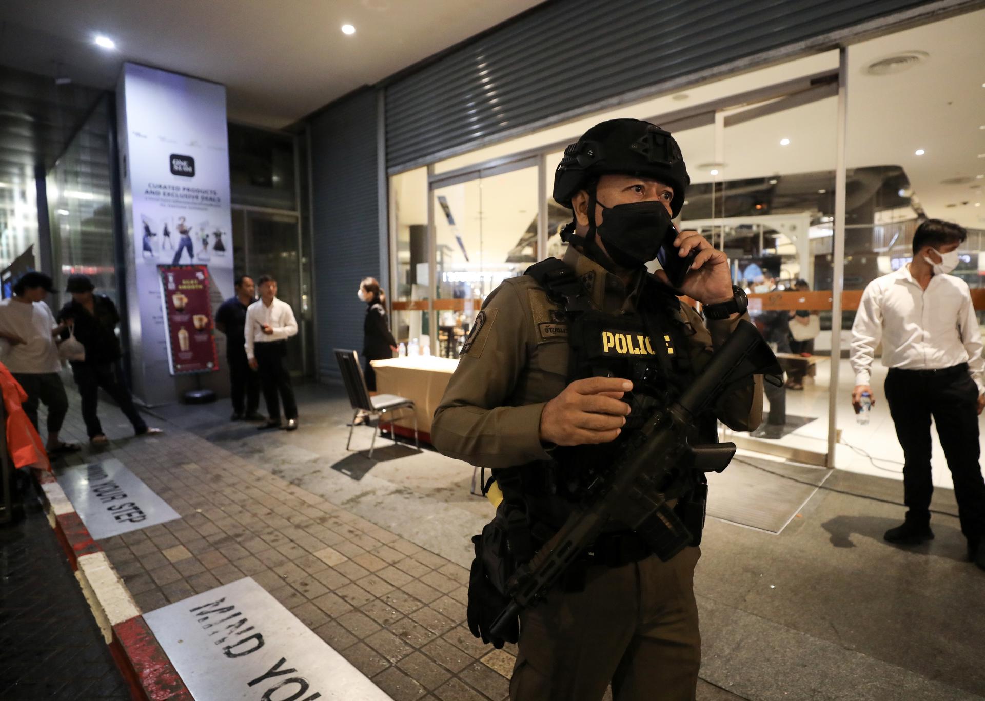 An armed police officer speaks on a mobile phone as he leaves the Siam Paragon shopping mall, after its premises were evacuated following gunshots, in Bangkok, Thailand, 03 October 2023. EFE/EPA/NARONG SANGNAK
