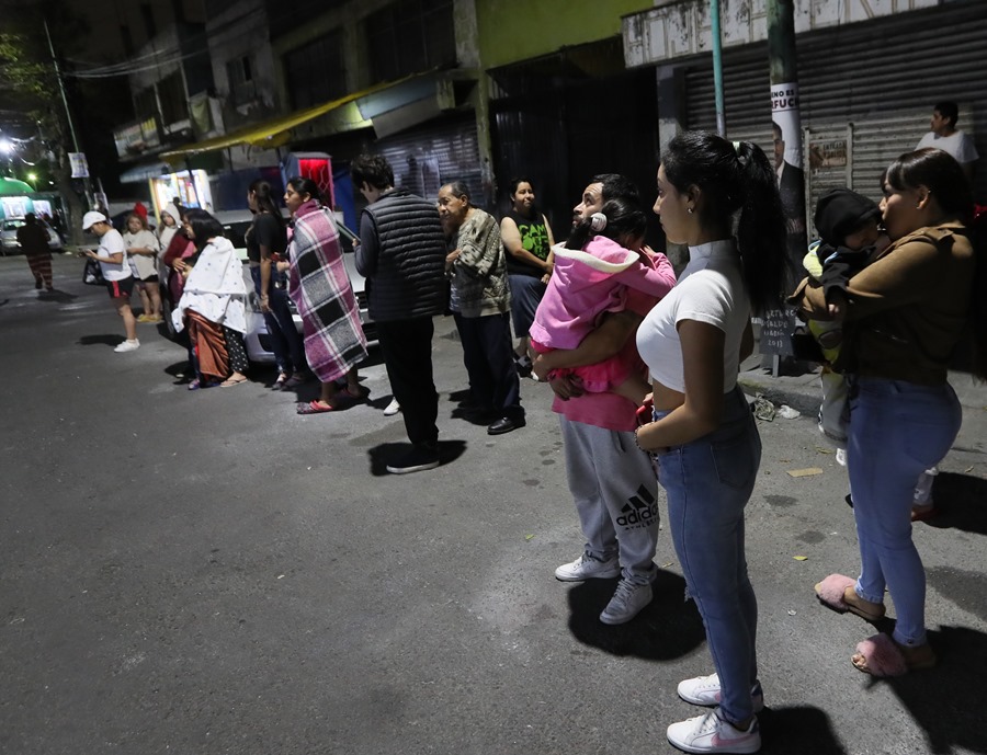 Personas permanecen a las afueras de un restaurante tras sonar la alerta sísmica hoy, en Ciudad de México (México).