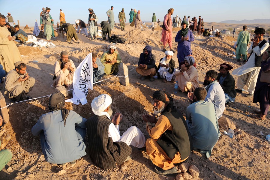
La gente ora después de enterrar a sus familiares que murieron en un terremoto en el distrito Zinda Jan de Herat