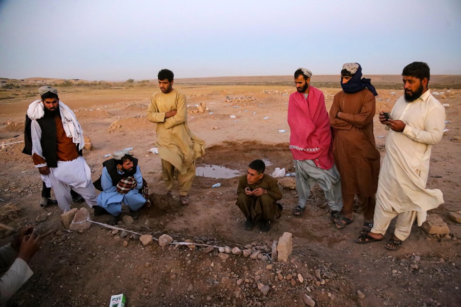 La gente reza ante la tumba de una víctima de un terremoto en el distrito de Zinda Jan de Herat