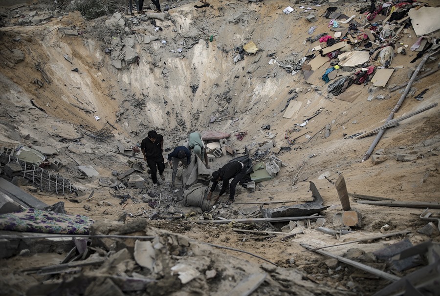 Palestinos buscan víctimas o supervivientes entre los restos de un edificio residencial tras un ataque israelí en Jan Yunis, al sur de la franja de Gaza