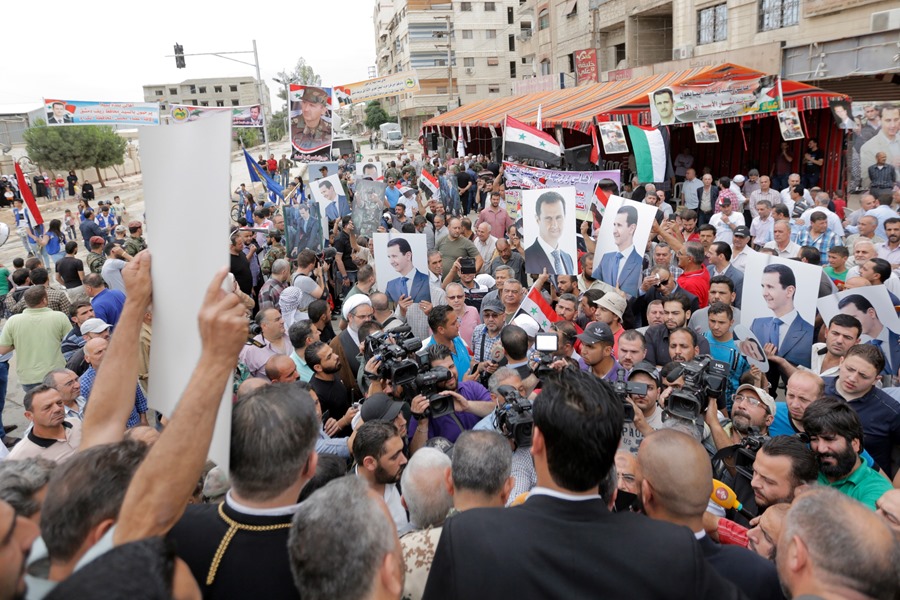 Ciudadanos muestran fotografías del presidente sirio, Bachar al-Ásad, durante un acto en Damasco