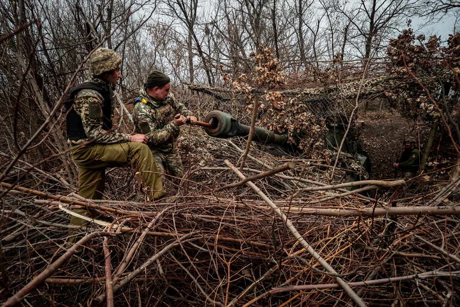 Militares ucranianos de la 65ª brigada mecanizada limpian el cañón de un obús de fabricación soviética en la región de Zaporiyia