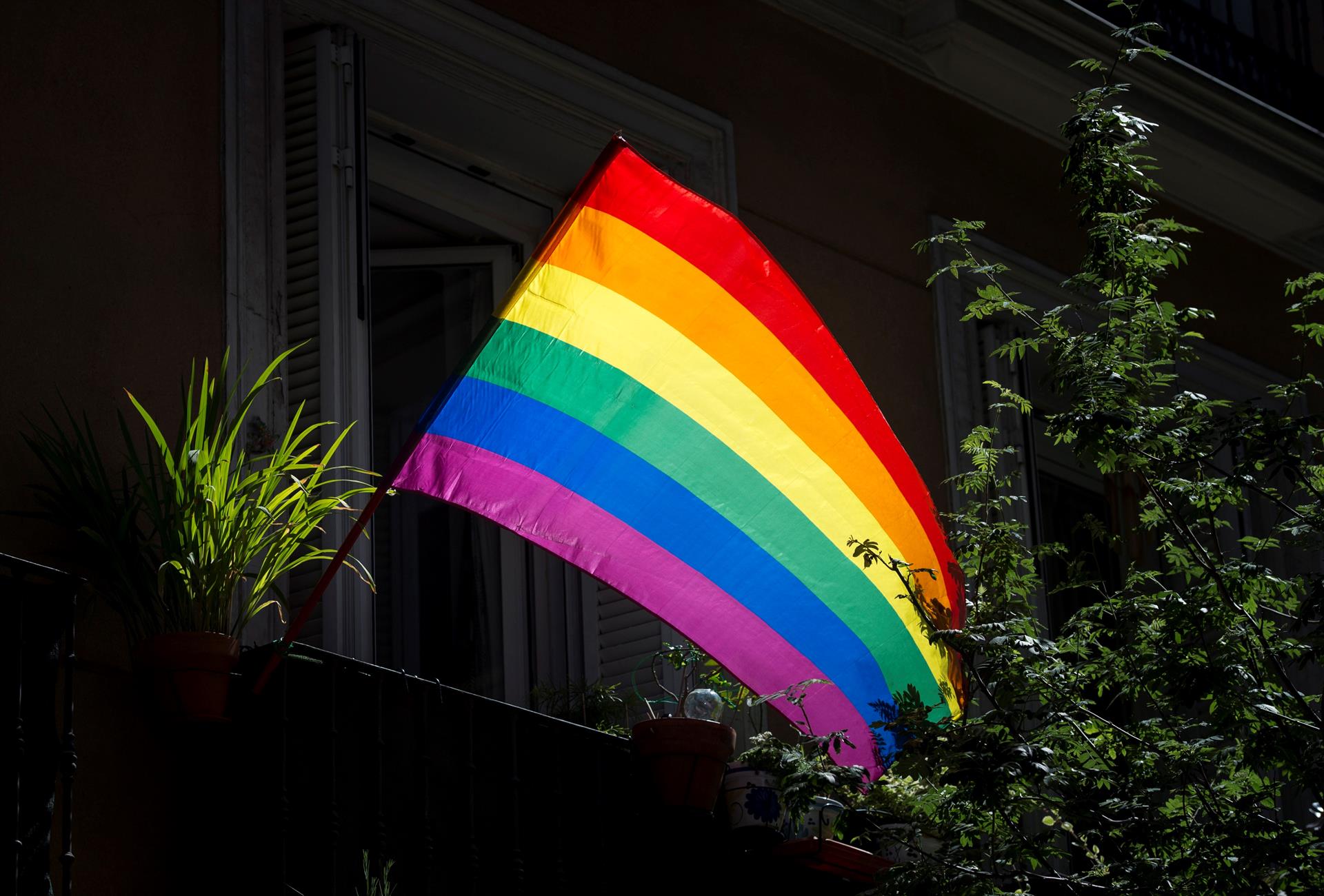 Una bandera gay cuelga de un balcón.
