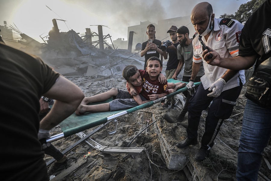 Palestinos cargan a hermanos heridos en una camilla después de recuperarlos de los escombros de una zona destruida tras los ataques aéreos israelíes en la ciudad de Gaza,