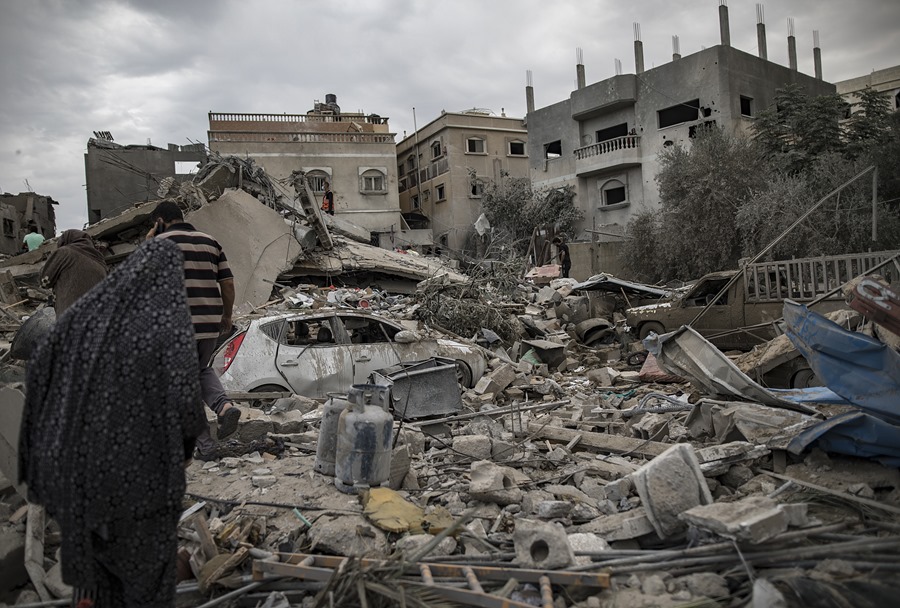 Palestinos buscan cuerpos y supervivientes en los escombros de un área residencial destruido por bombardeos israelíes.