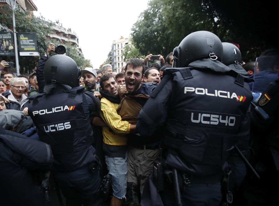 Agentes antidisturbios de la Policía Nacional forman un cordón de seguridad frente al colegio Ramón Llull de Barcelona el 1 de octubre de 2017