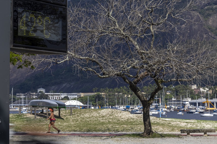 Una persona trota por un parque mientras un termómetro marca una temperatura de 42 grados, en Río de Janeiro