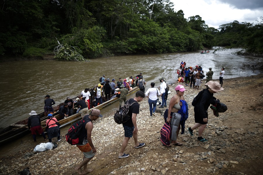 Migrantes bajan de canoas para ser trasladados a una estación de recepción migratoria en Lajas Blancas, Metetí, Darién