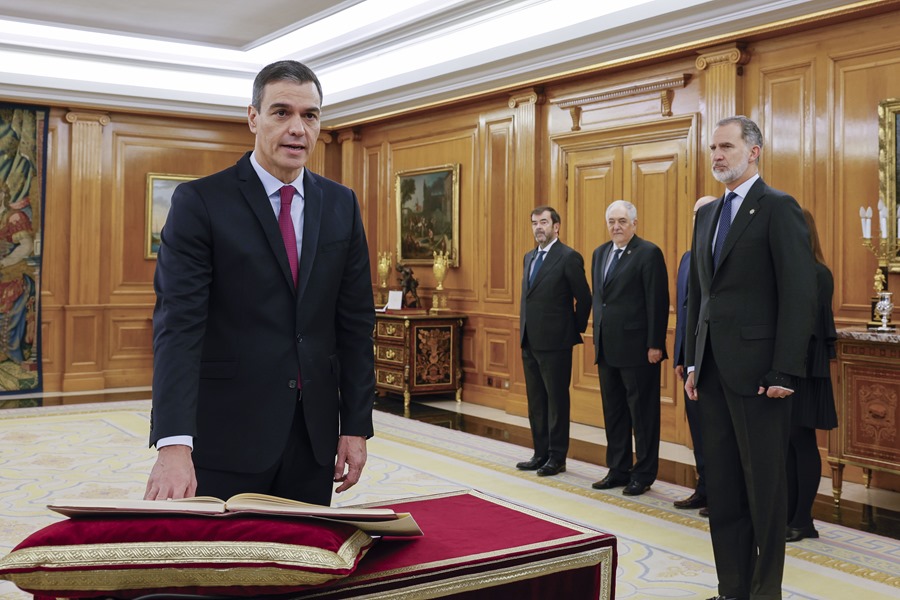 Pedro Sánchez (i) promete su cargo de presidente del Gobierno ante el rey Felipe VI (d) y un ejemplar de la Constitución, este viernes en el Salón de Audiencias del Palacio de la Zarzuela en Madrid.