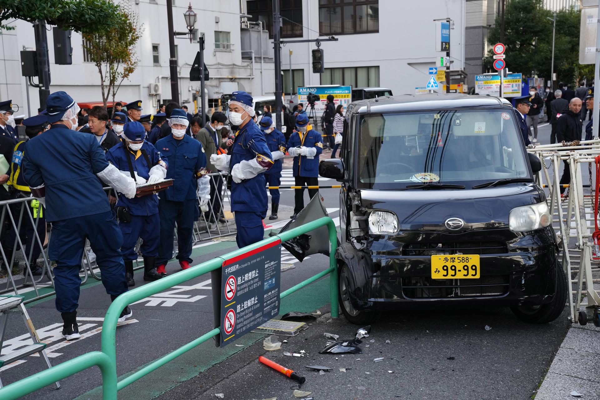 Japanese policemen investigate the scene after a driver crashed a car into a police barricade near the Israel Embassy, in Tokyo, Japan, 16 November 2023. EFE-EPA/KIMIMASA MAYAMA
