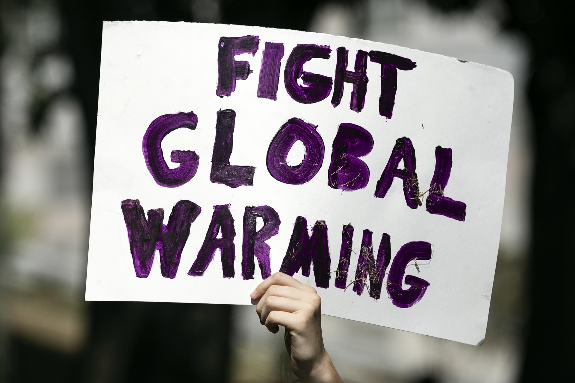 A demonstrator holds a sign during a Global Climate Strike rally, in Los Angeles, California, USA, 23 September 2022. EFE-EPA/FILE/ETIENNE LAURENT