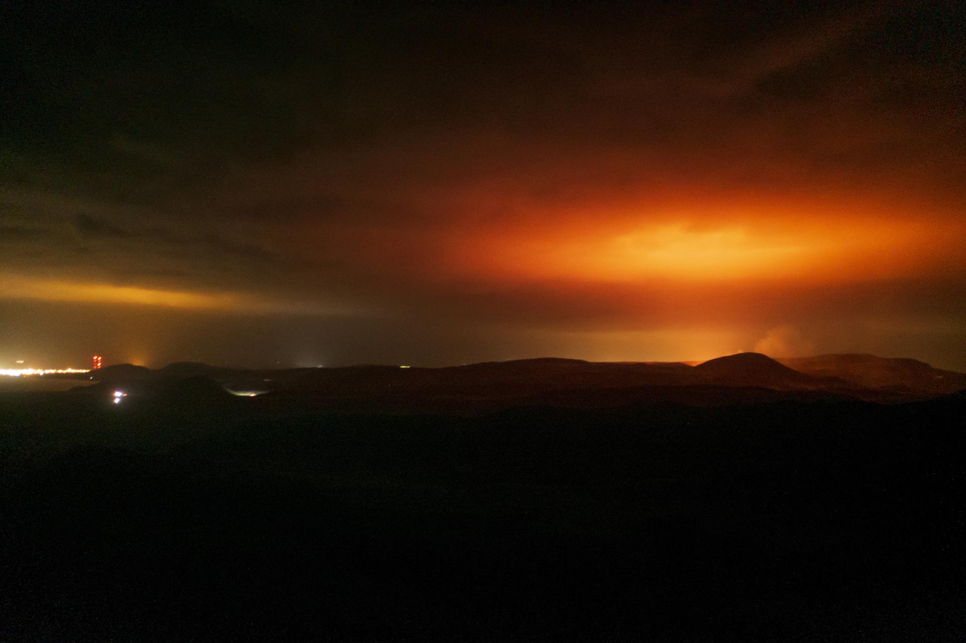 (FILE) The red glare from the volcano eruption lights the night sky over Grindavik (L) on the Reykjanes Peninsula, Iceland, early 20 March 2021 (picture taken with a drone). EFE/EPA/GOLLI / ICELANDREVIEW MANDATORY CREDIT