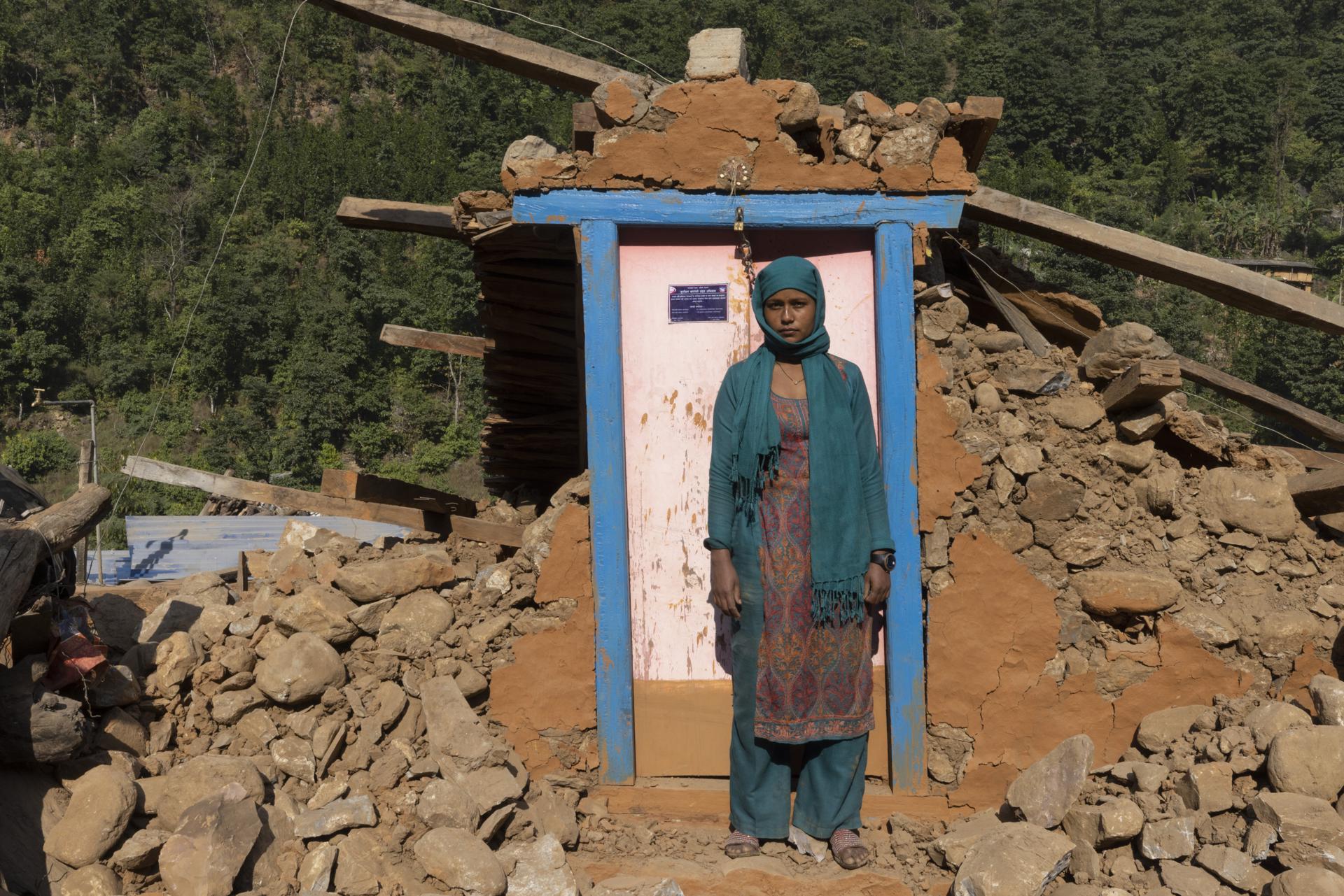 A woman stands on the door of her damaged house in Chepare village, West Rukum, Nepal, 06 November 2023. EFE-EPA/NARENDRA SHRESTHA