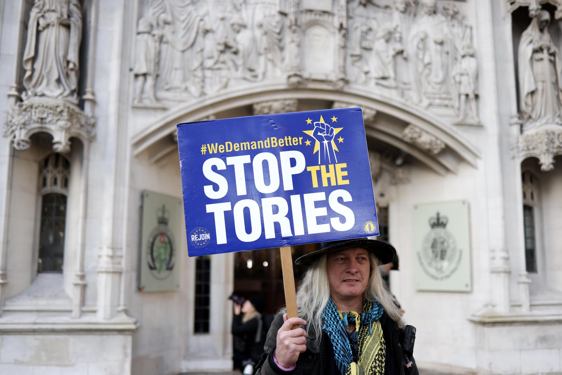 An anti-government protester holds a placard outside the Supreme Court of the United Kingdom in London, Britain, 15 November 2023. EFE-EPA/NEIL HALL
