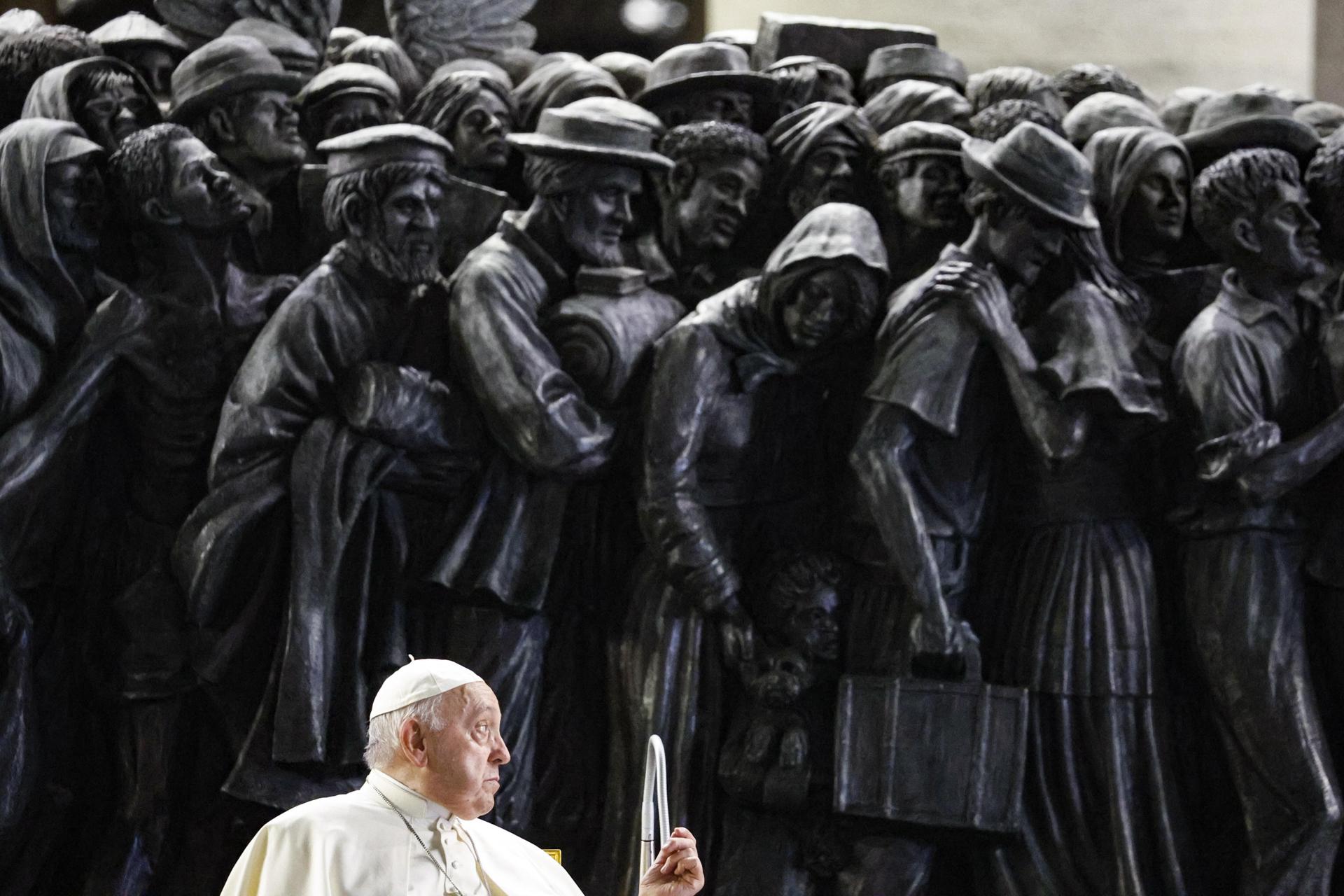 Foto de archivo tomada el pasado 19 de octubre: el papa atiende a una plegaria ante la escultura que recuerda desde 2019 en la plaza de San Pedro, en el Vaticano, a los migrantes y refugiados. EFE/EPA/Fabio Frustaci