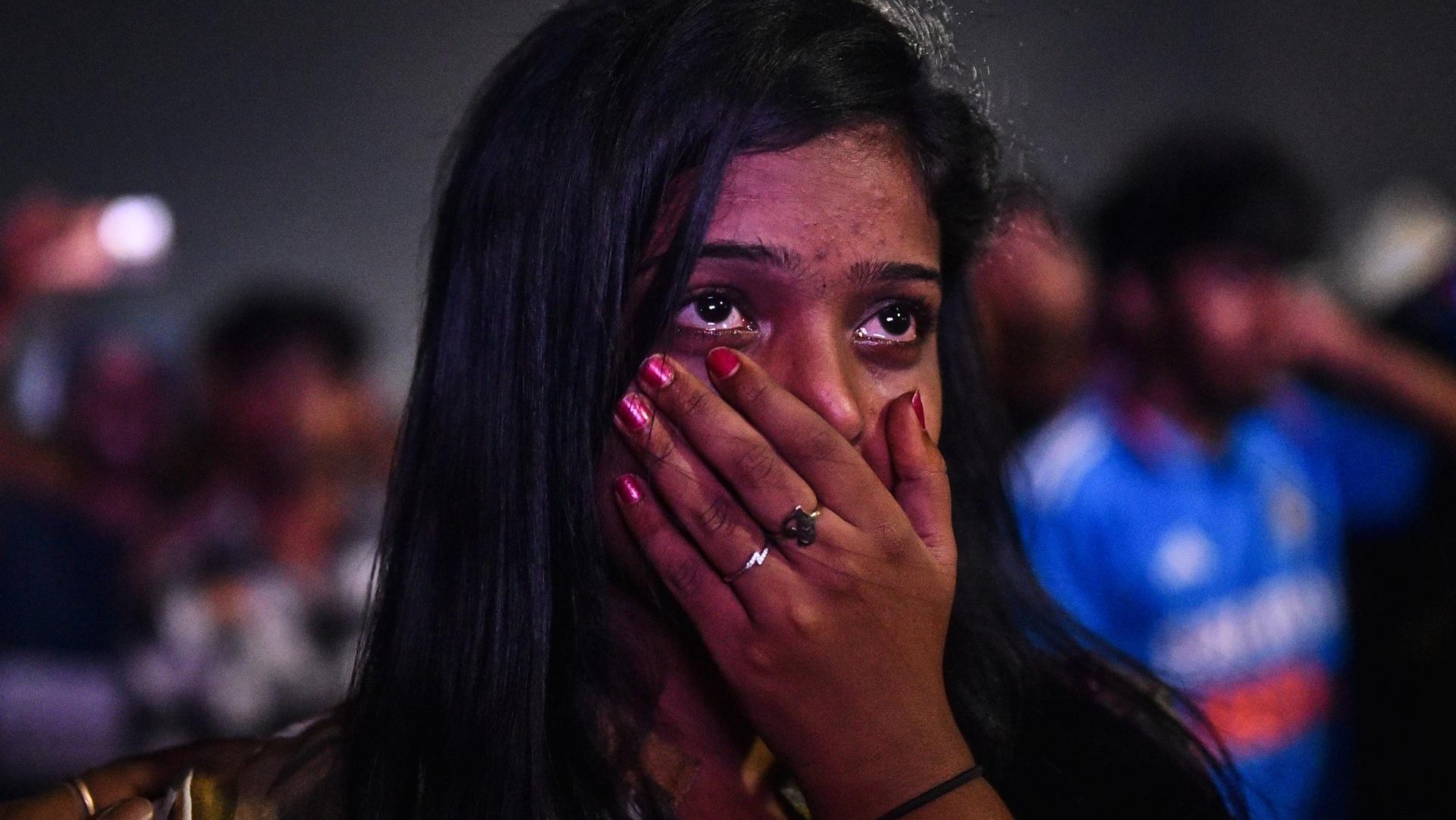 An Indian cricket fan reacts as she watches the live broadcast of the ICC Men's Cricket 2023 World Cup final match between India and Australia on a big screen at Edward Elliot's Beach, in Chennai, India, 19 November 2023. EFE-EPA/IDREES MOHAMMED