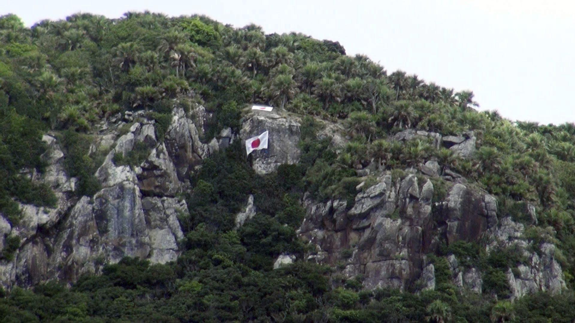 An image released on August 20, 2012 by Japan's Sakura channel shows a Japanese flag placed by far-right group Ganbare Nippon on a rocky area of one of the disputed Senkaku Islands in the East China Sea. EFE-EPA FILE/Stringer/USE PROHIBITED IN CHINA AND JAPAN