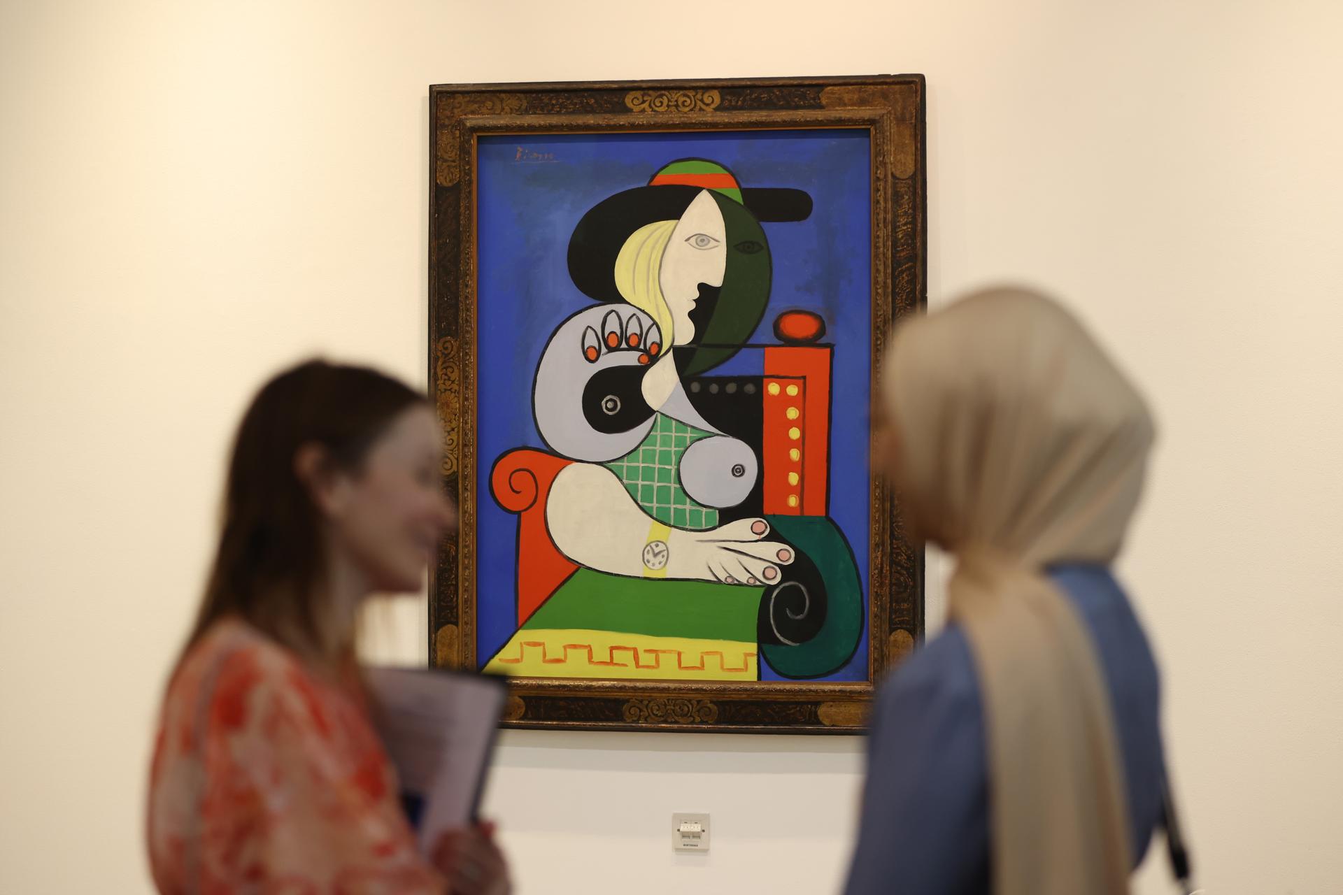 People look at a painting titled 'Femme a la Montre or Woman with a Watch' by Pablo Picasso at Sotheby's Dubai gallery in Dubai, United Arab Emirates, 25 September 2023. EFE-EPA FILE/ALI HAIDER