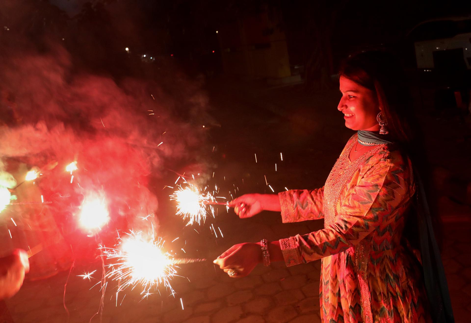 An Indian woman lights sparklers during Diwali celebrations near New Delhi, India, 12 November 2023. EFE-EPA/HARISH TYAGI