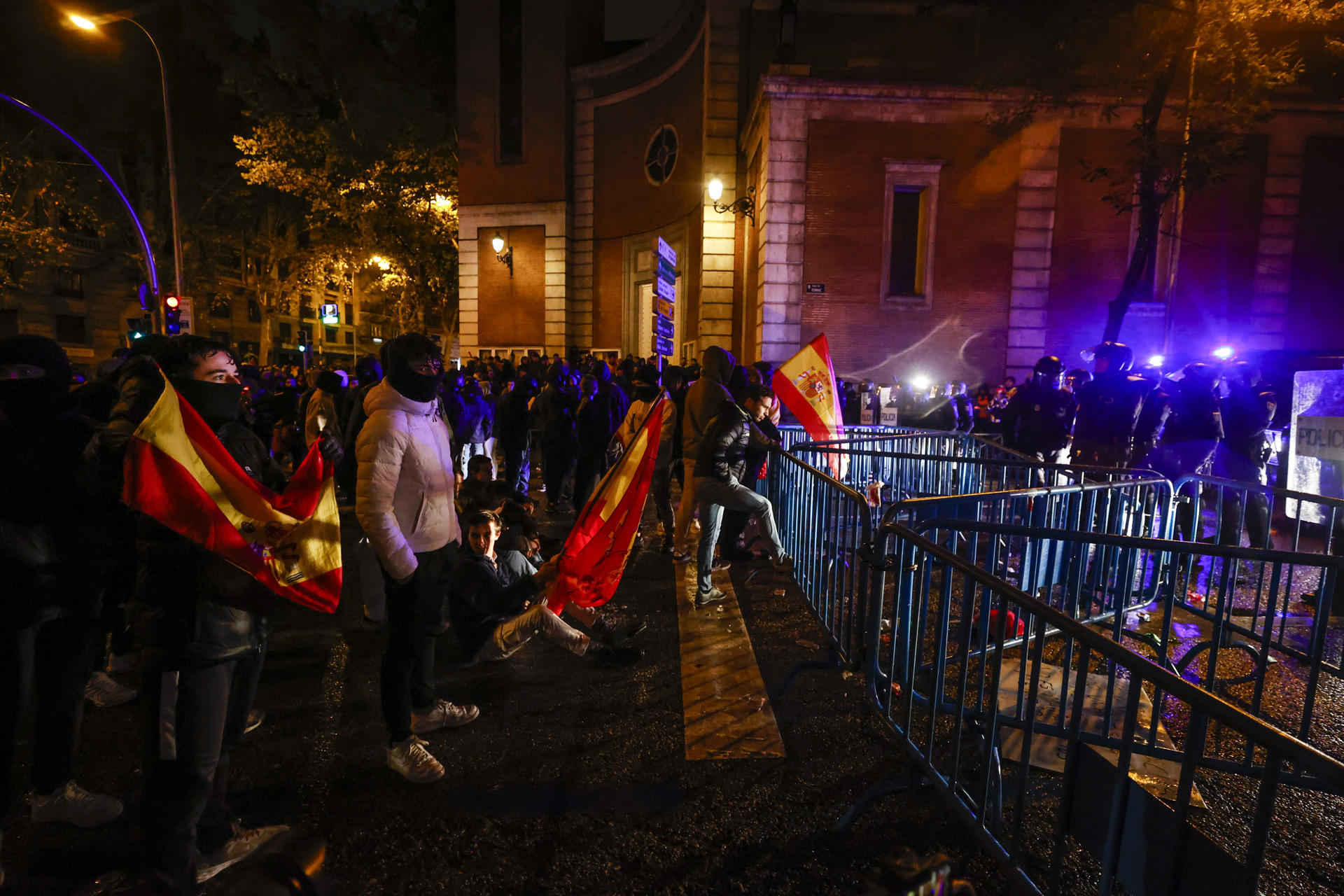 Manifestantes frente a miembros de la Policía en la calle Ferraz, en Madrid, en una nueva jornada de protesta contra la amnistía celebrada este viernes en la capital. EFE/Javier Lizón

