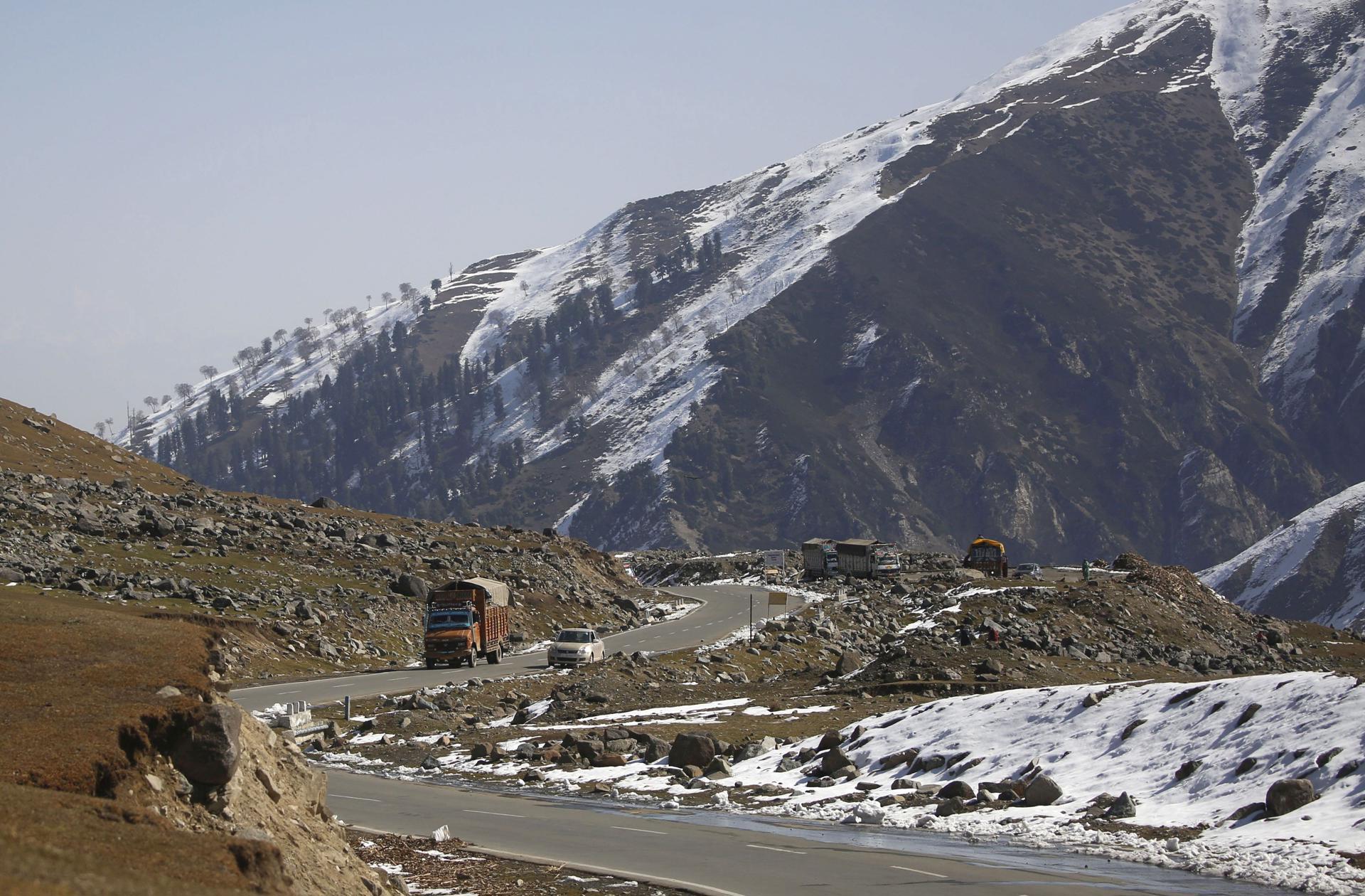 (FILE) Vehicles cross a road near snow covered mountains at Mughal Road, some 80 kilometers south of Srinagar, the summer capital of Indian Kashmir, India. EFE/EPA/FAROOQ KHAN