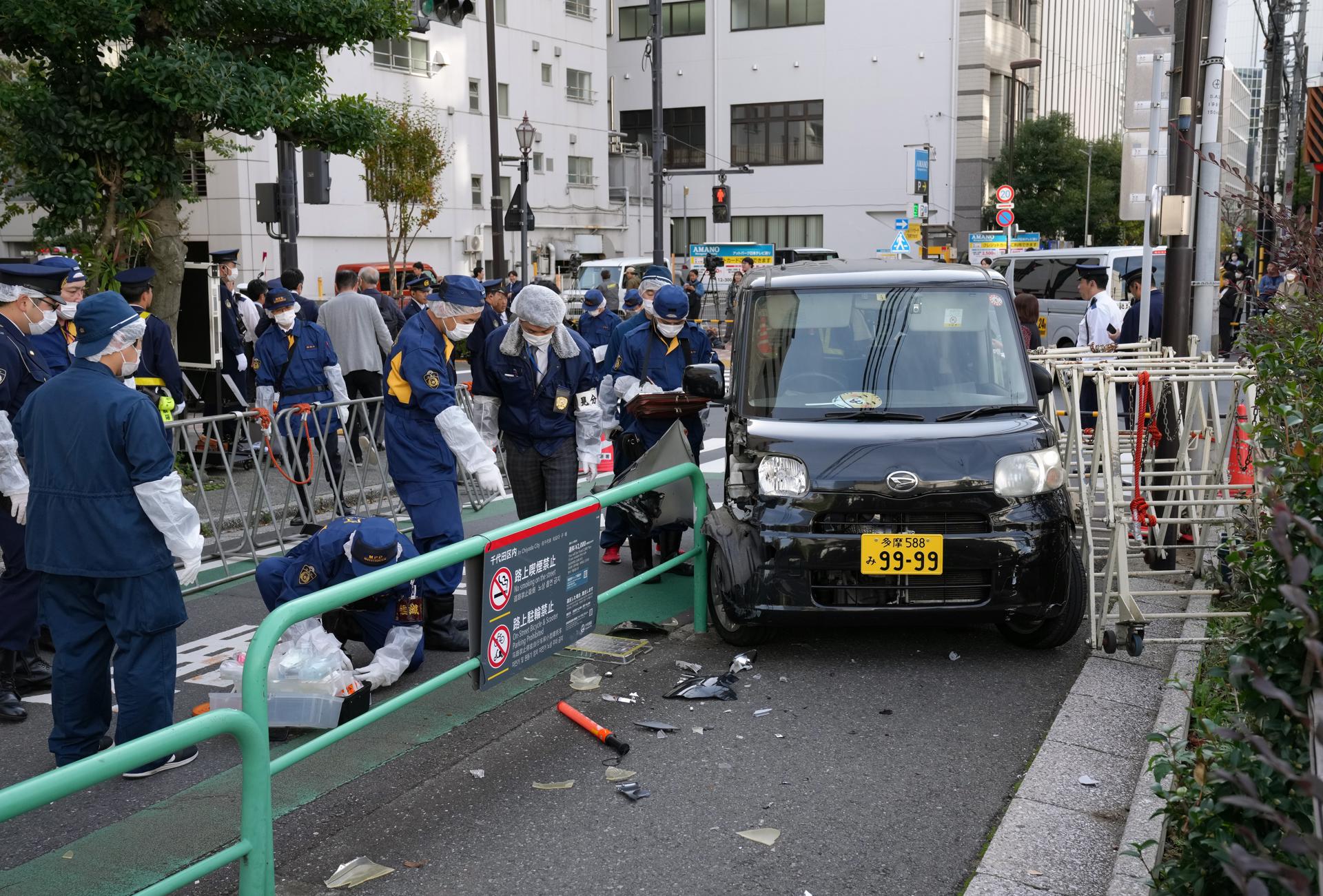 Japanese policemen investigate the scene after a driver crashed a car into a police barricade near the Israel Embassy, in Tokyo, Japan, 16 November 2023. EFE-EPA/KIMIMASA MAYAMA