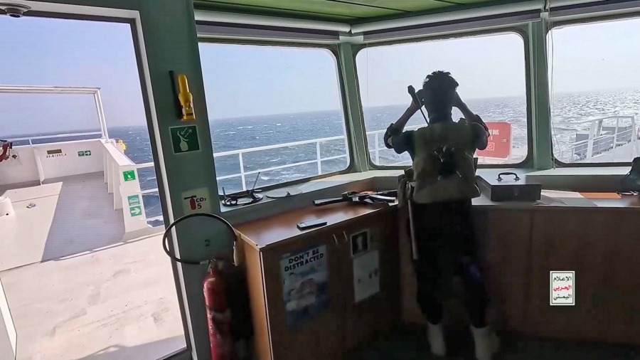 un combatiente hutí vigilando a bordo del barco incautado Galaxy Leader tres días después de que los hutíes lo capturaran en el Mar Rojo