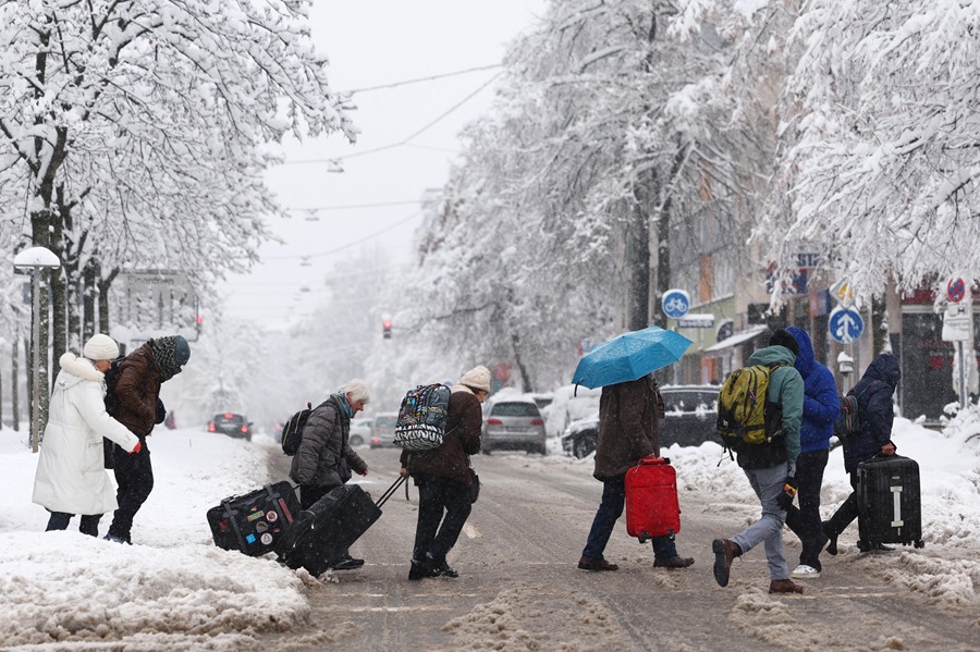 Un grupo de personas trata de cruzar una calle nevada en Múnich.