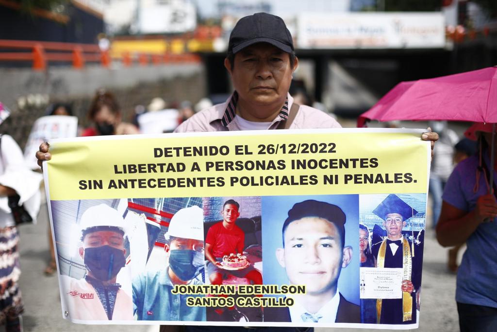 Un hombre sostiene un cartel con fotografías de un joven detenido en 2022 durante una protesta, en San Salvador (El Salvador), en una fotografía de archivo. EFE/Rodrigo Sura
