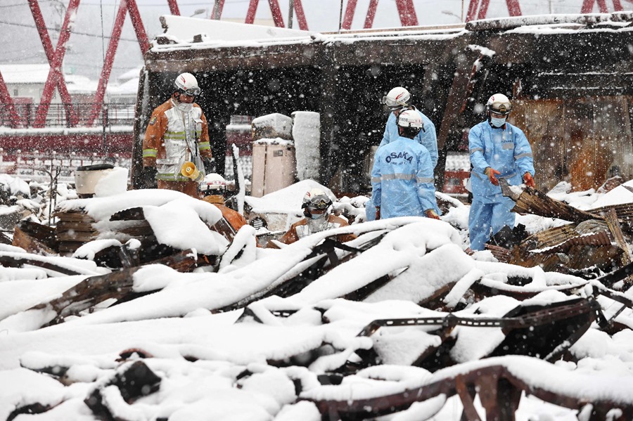 Bomberos buscan víctimas del terremoto bajo una intensa nevada en Asaichi, en la prefectura de Ishikawa, Japón