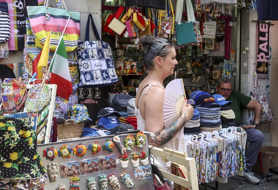 Una mujer camina por las calles de Palermo, en Sicilia, un día de intenso calor el pasado verano.