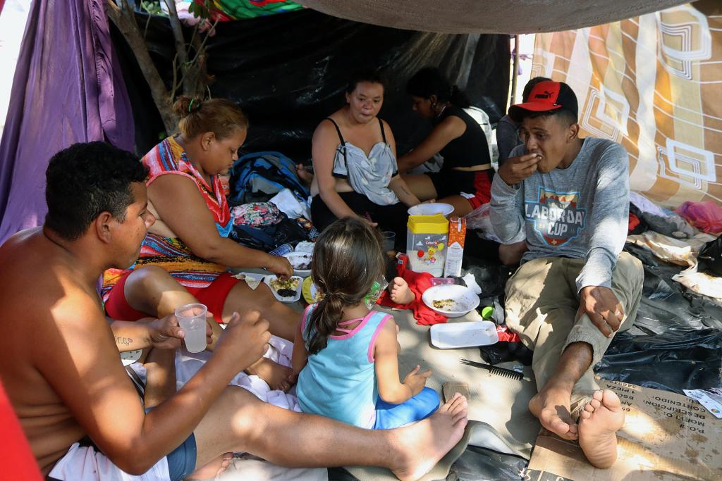 Migrantes en caravana hacia Estados Unidos comparten alimentos en un campamento improvisado hoy, en el municipio de Mapastepec, estado de Chiapas (México). EFE/Juan Manuel Blanco
