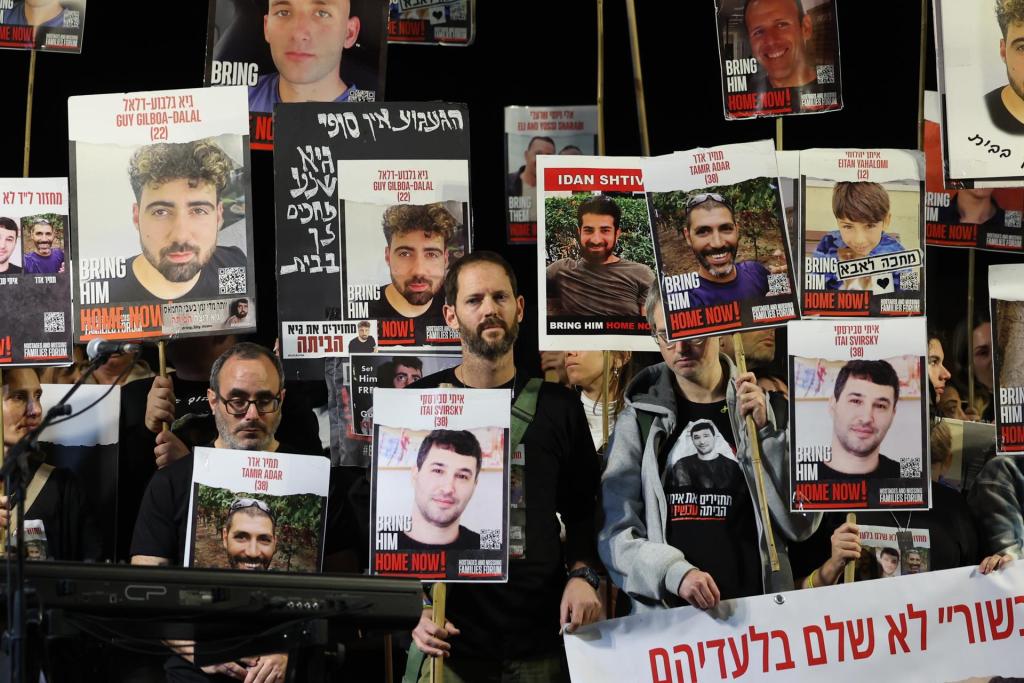 Simpatizantes y familiares sostienen fotografías de rehenes retenidos por Hamás en Gaza mientras participan en una manifestación pidiendo su liberación, frente a la base militar de Kirya, en Tel Aviv (Israel), este 6 de enero de 2024. EFE/EPA/Abir Sultan
