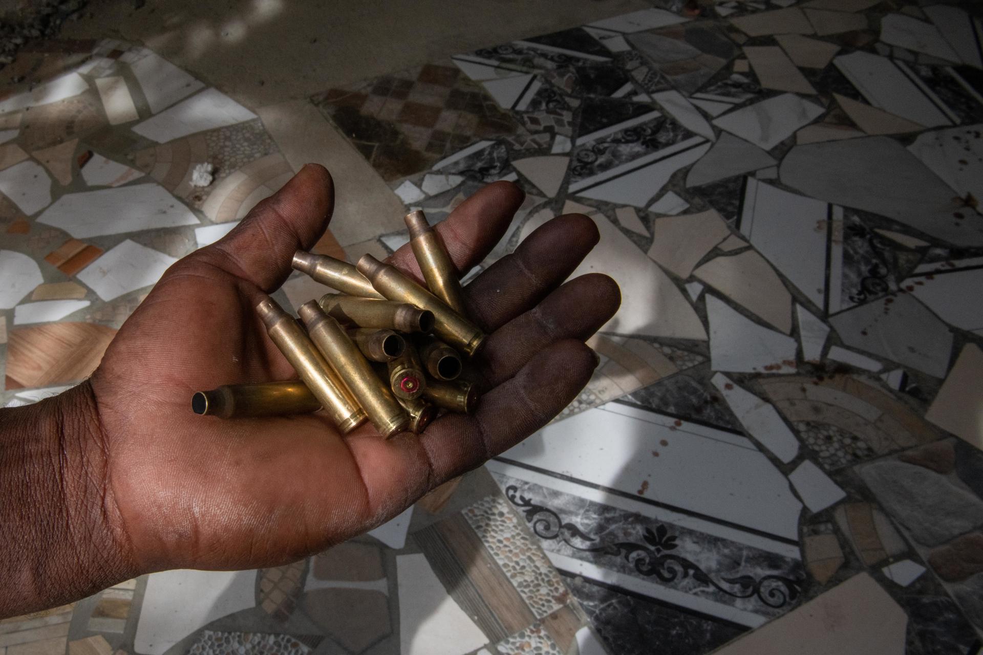 Un empleado muestra casquillos de balas en la puerta del hospital del populoso barrio de Cité-Soleil, en Puerto Príncipe (Haití). Foto de archivo. EFE/ Johnson Sabin