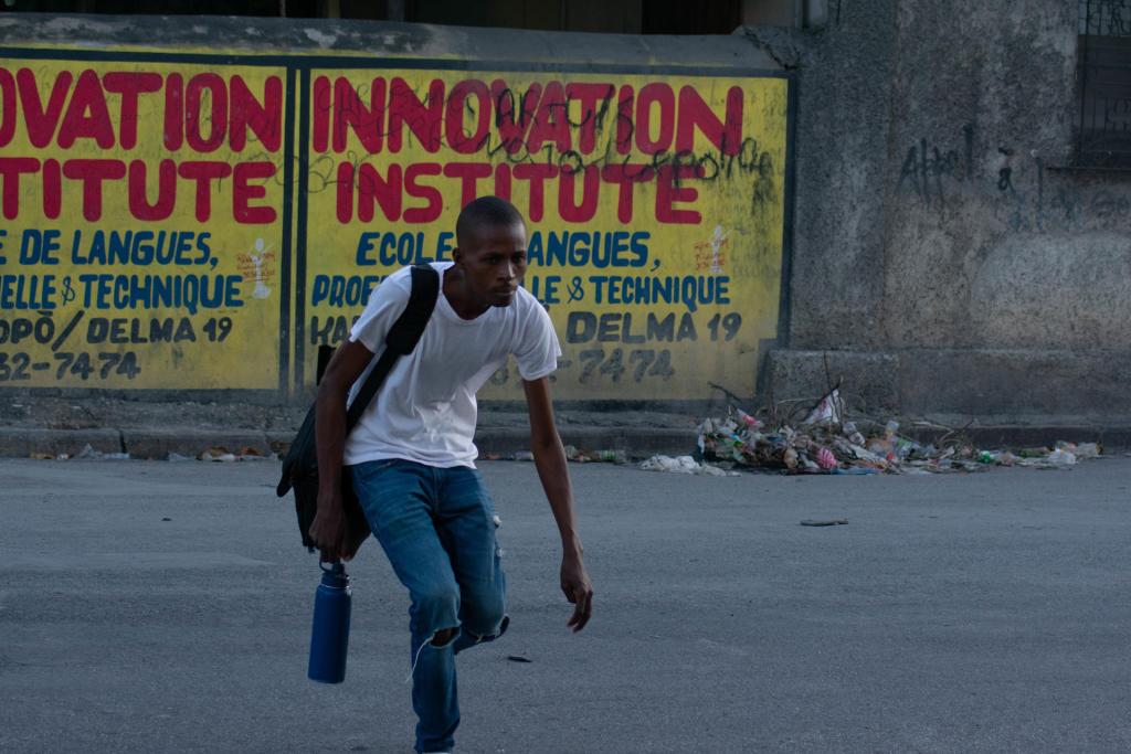 Un hombre trata de resguardarse durante los actos de saqueo en el centro de la ciudad, este sábado en Puerto Príncipe (Haití).  EFE/ Siffroy Clarens
