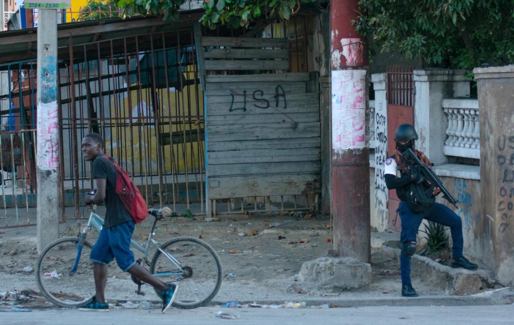 Un policía vigila durante los actos de saqueo en el centro de la ciudad, este sábado en Puerto Príncipe (Haití).  EFE/ Siffroy Clarens
